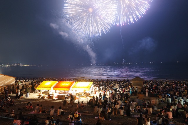 花火に照らされる浜辺